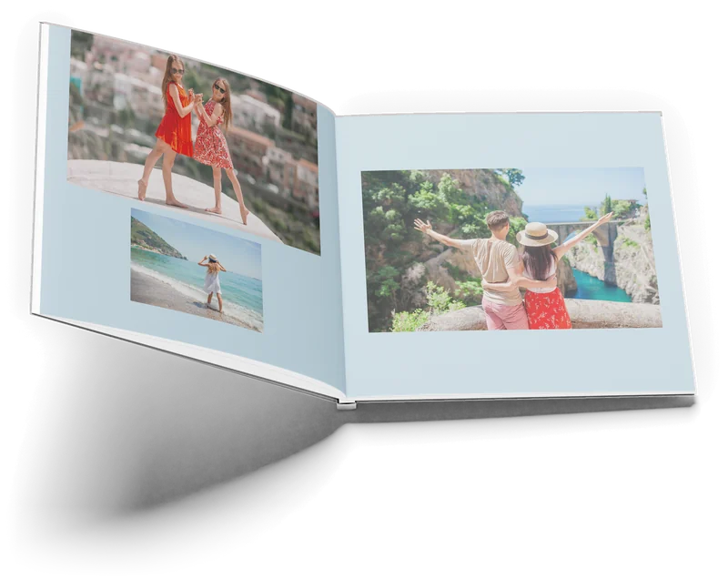 Het boek Amalfi open op pagina 14 en 15: links twee meisjes voor een dorp op de helling en een meisje aan zee, rechts een koppel boven de kloof van Furore